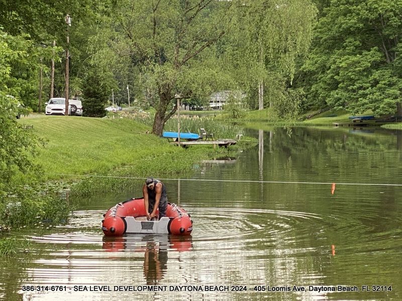 A man is sitting in an inflatable boat in a lake