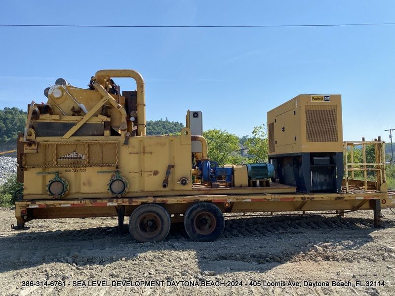 A large yellow machine is sitting on top of a trailer