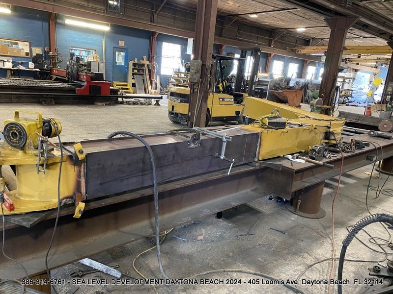 A large piece of metal is being worked on in a factory