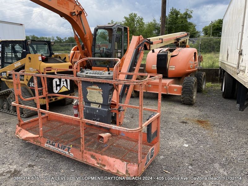 A cat excavator is parked next to a bucket lift.