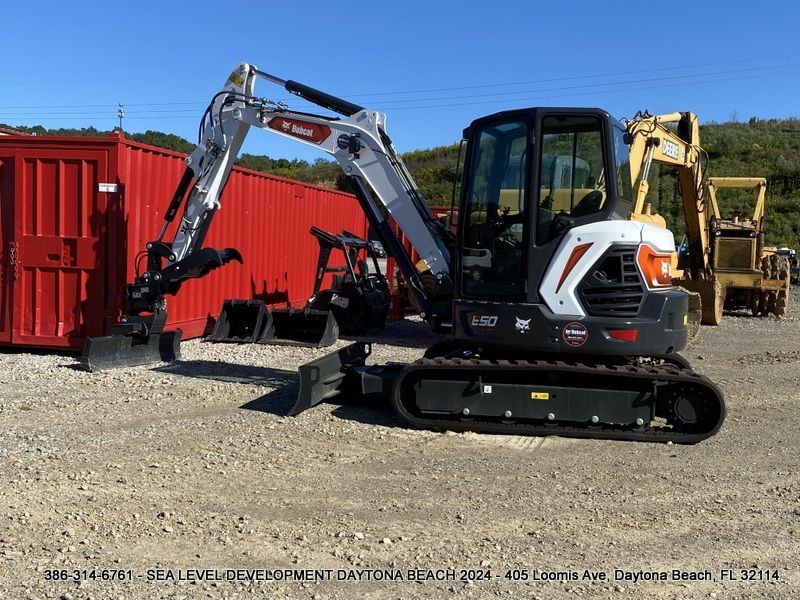 A bobcat excavator is parked in a gravel lot