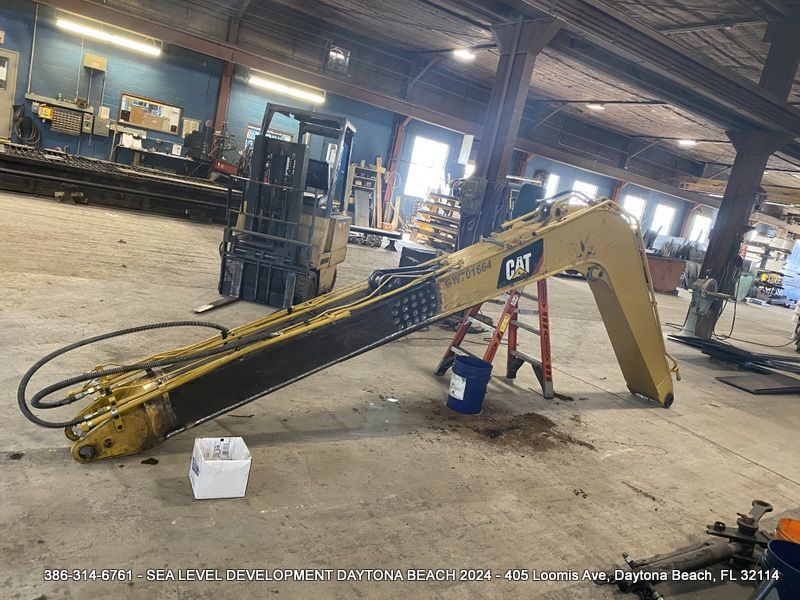 A yellow cat excavator is sitting in a warehouse
