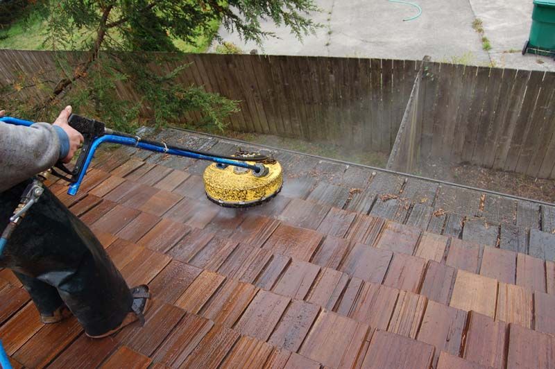 a person is cleaning a wooden deck with a machine .