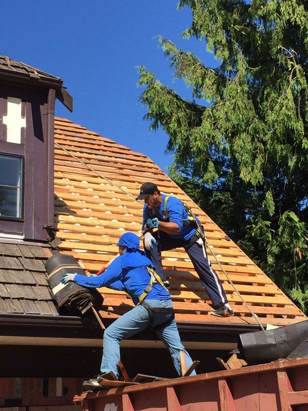 two men are working on the roof of a building