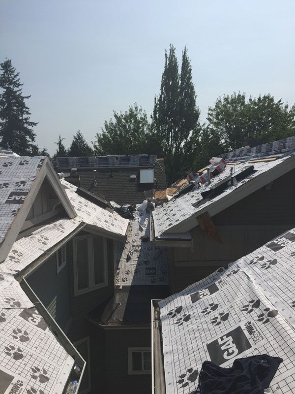 the roof of a house is being covered with 3m roofing paper