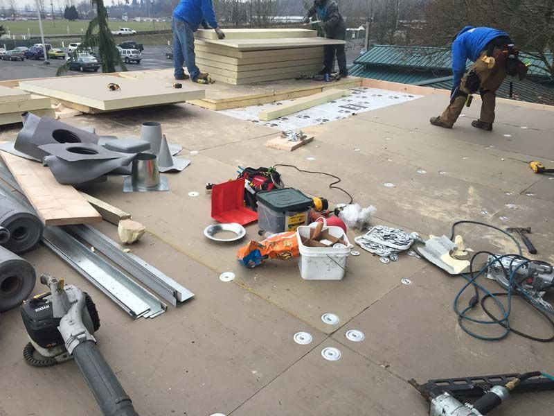 a group of people are working on a roof .