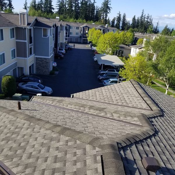 an aerial view of a apartment complex with cars parked in the driveway