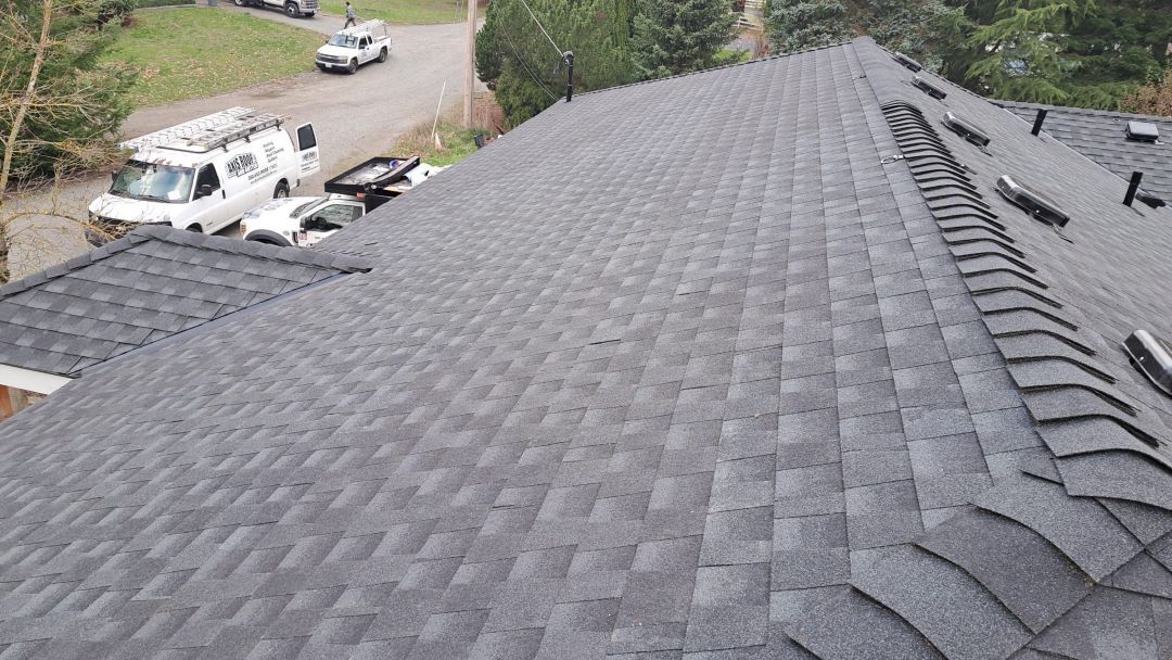 a roof with a lot of shingles on it is being installed on a house .