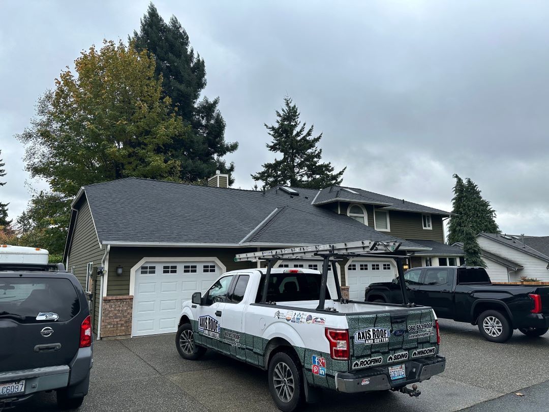 a truck is parked in front of a house with a roof .