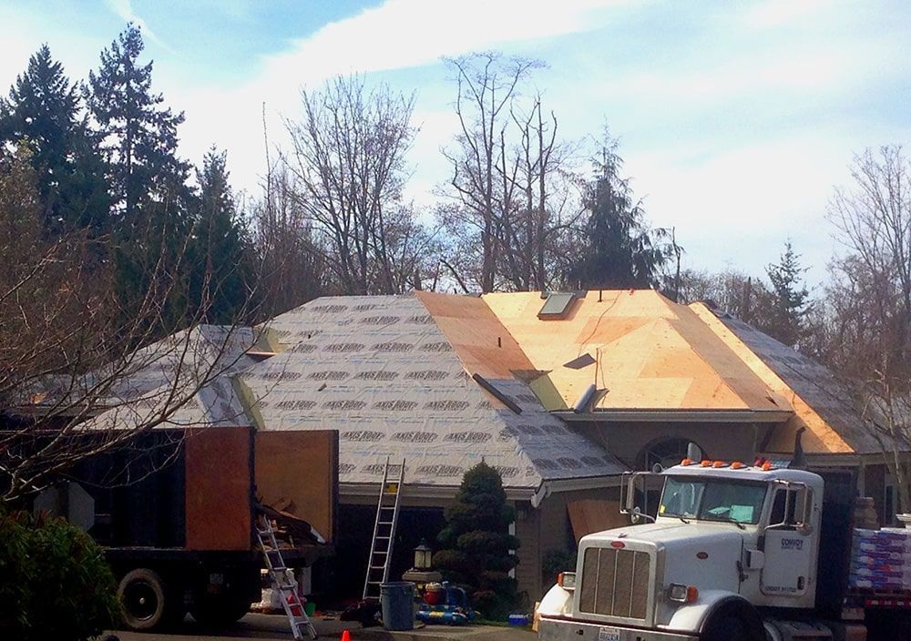 a white semi truck is parked in front of a house under construction