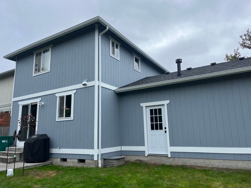 the back of a blue house with white trim and a white door .