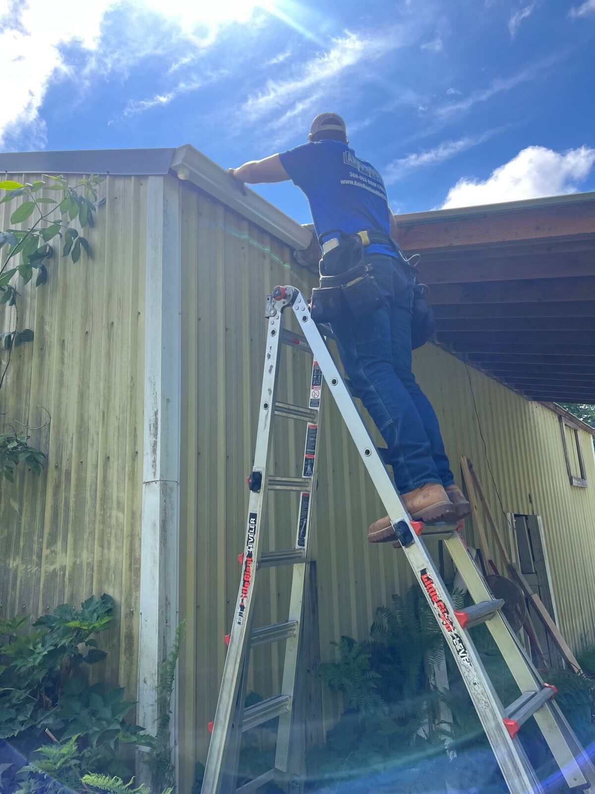 a man is standing on a ladder next to a building .