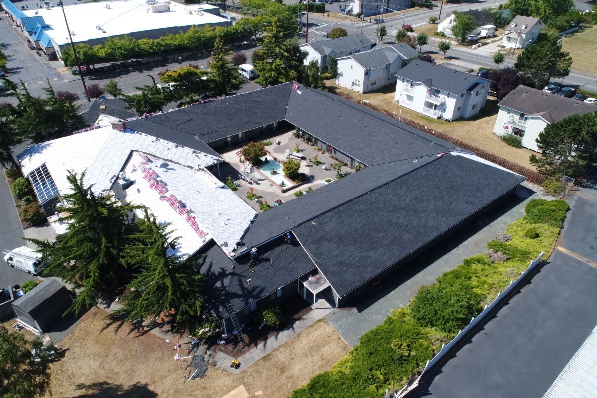 an aerial view of a large building with a pool in the middle