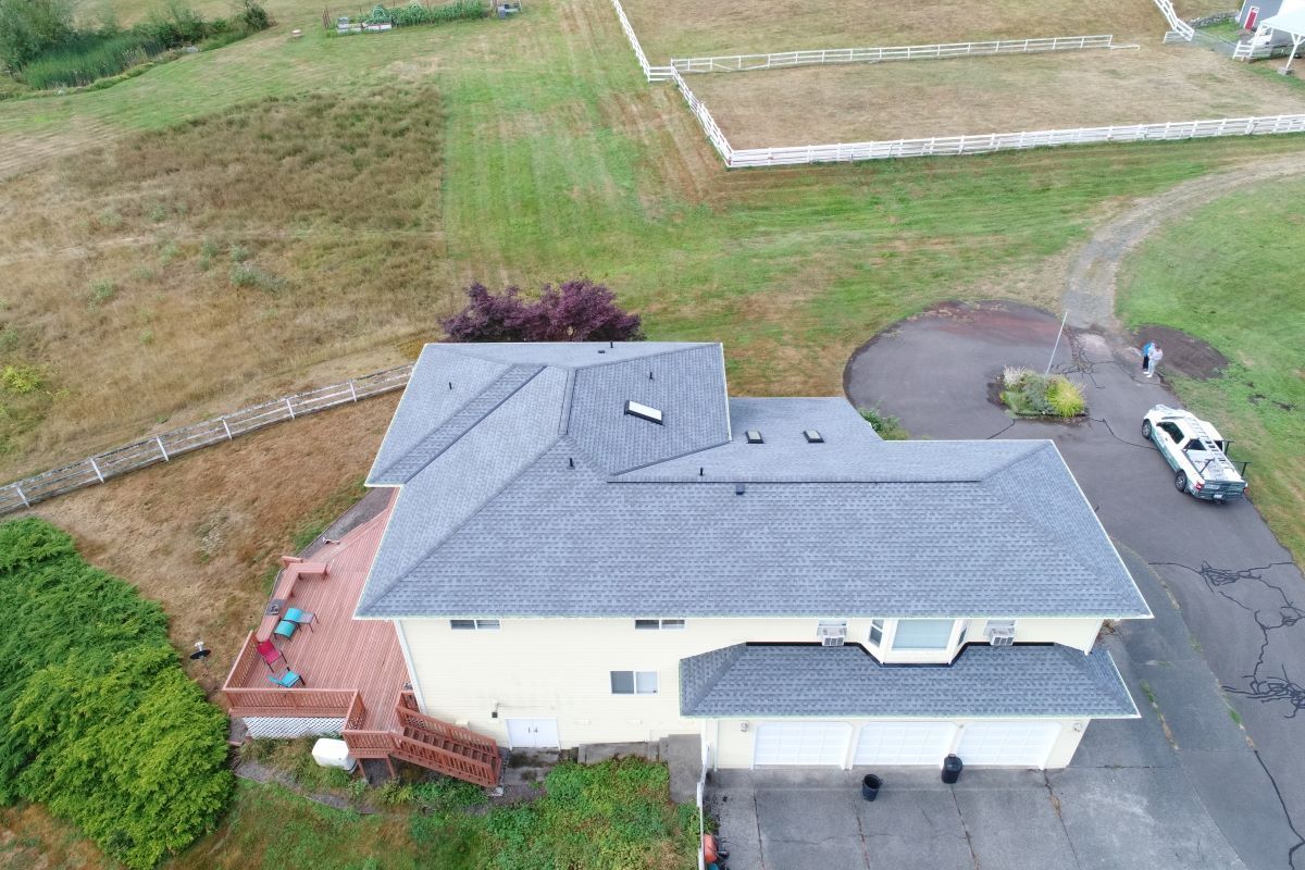 an aerial view of a house with a roof and a car parked in front of it .