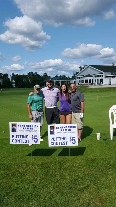 a group of people are posing for a picture on a golf course .