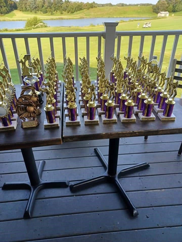a bunch of trophies are on a table on a deck