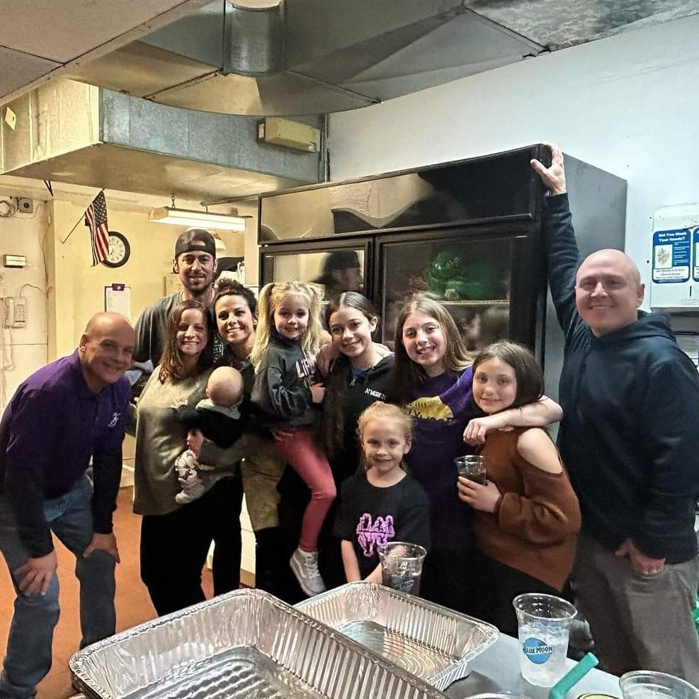 a group of people are posing for a picture in a kitchen .