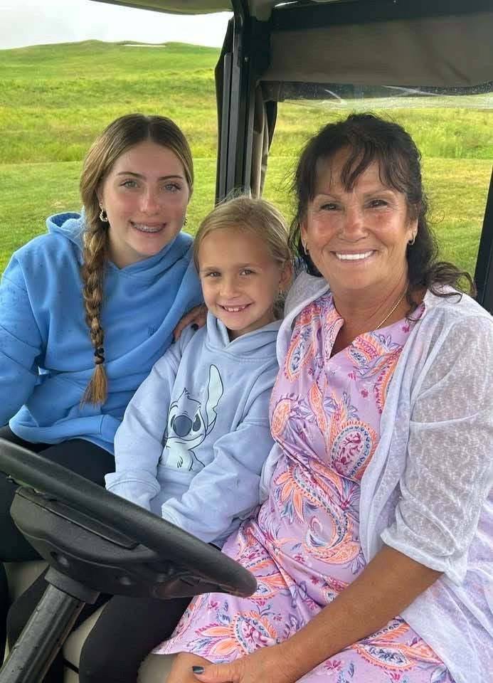 Woman and two young girls in golf cart, smiling at camera during the 2025 Remembering Jamie Golf Tournament at McCullugh's Emerald Links Golf Course in Egg Harbor Township, New Jersey