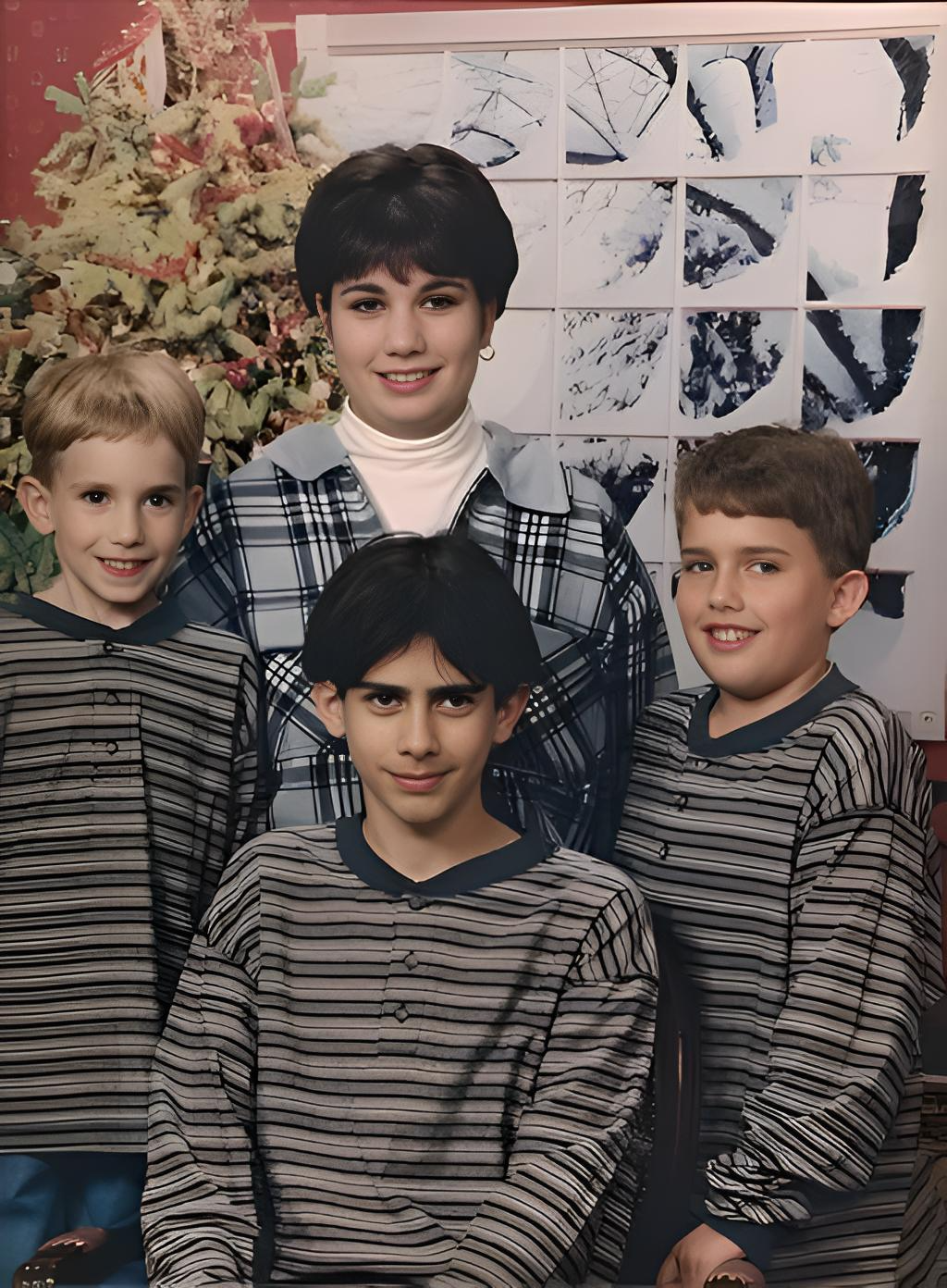 jamie crescenzo and her brothers in striped shirts pose near a Christmas tree. One wears a blue plaid shirt over a turtleneck