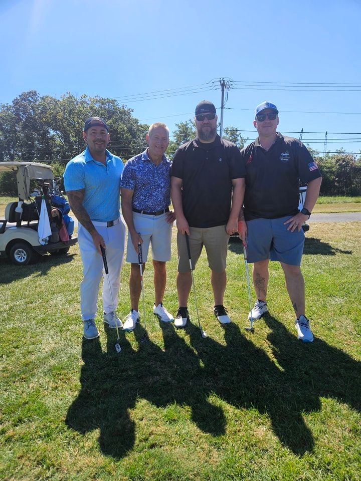 A group of men are posing for a picture on a golf course