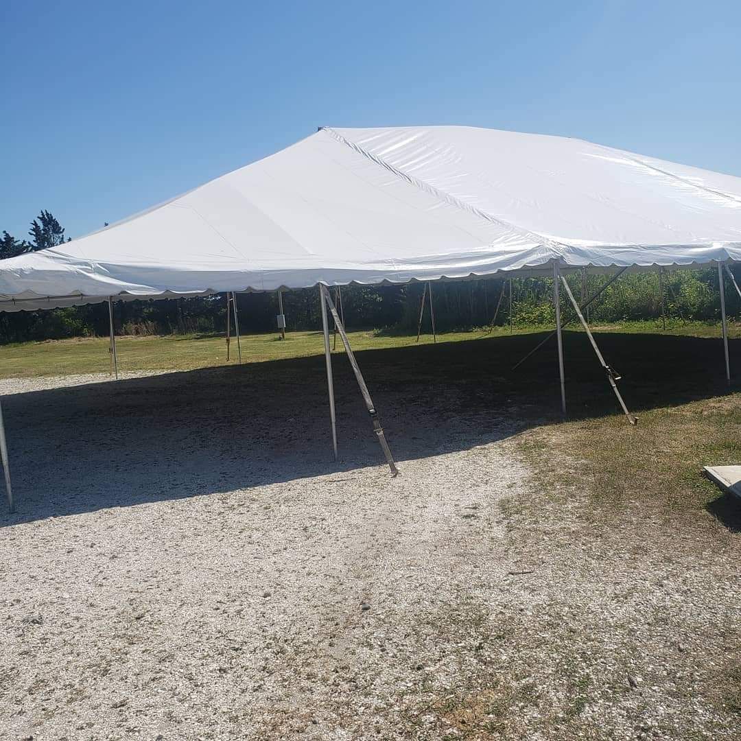 a large white tent is sitting in a gravel area