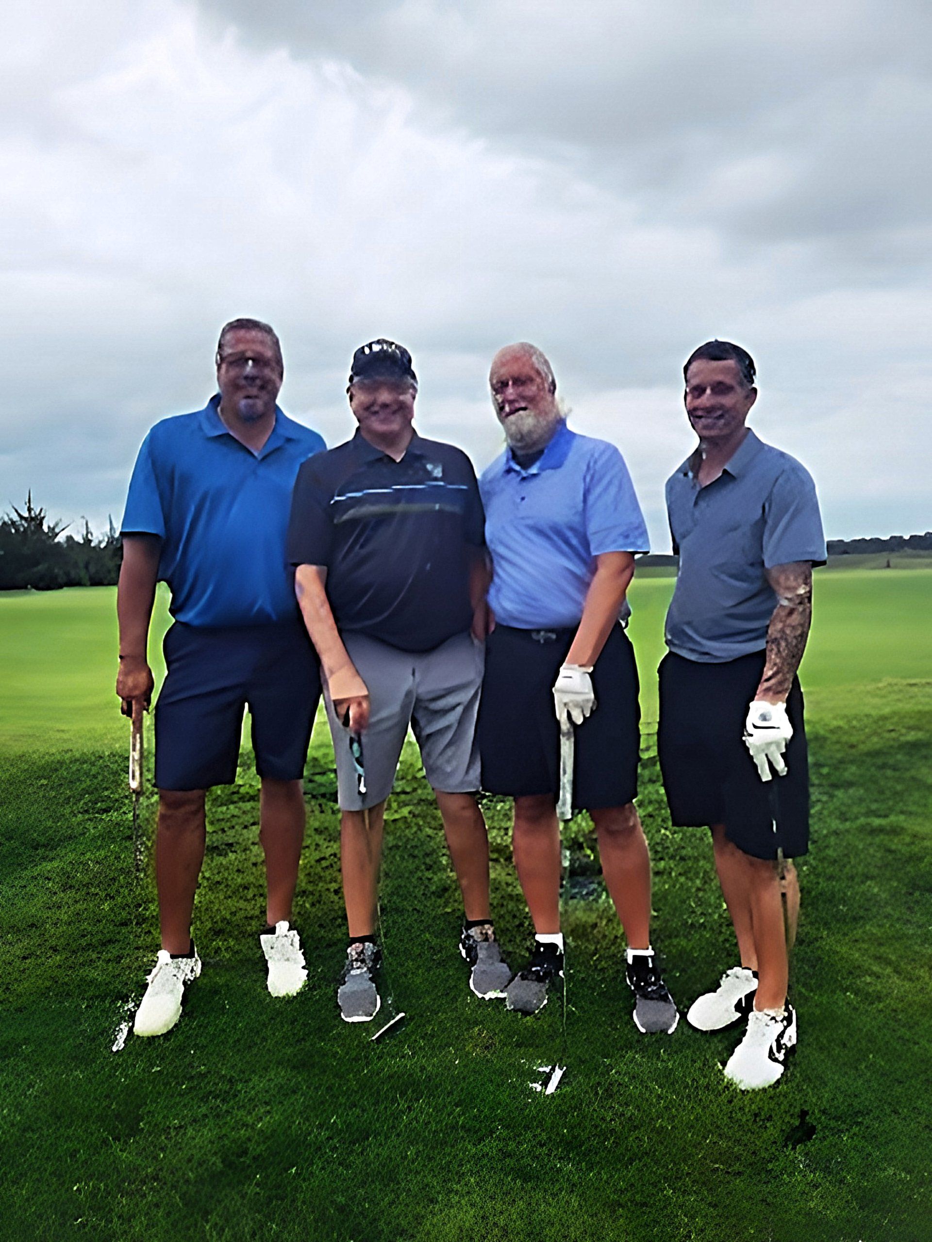 four men are posing for a picture on a golf course
