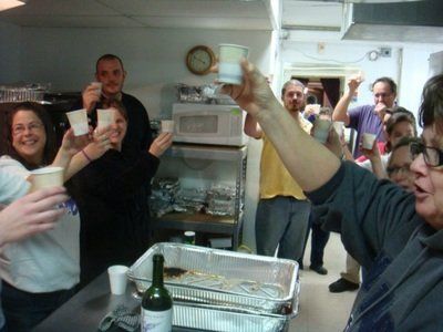 a group of people are toasting in a kitchen