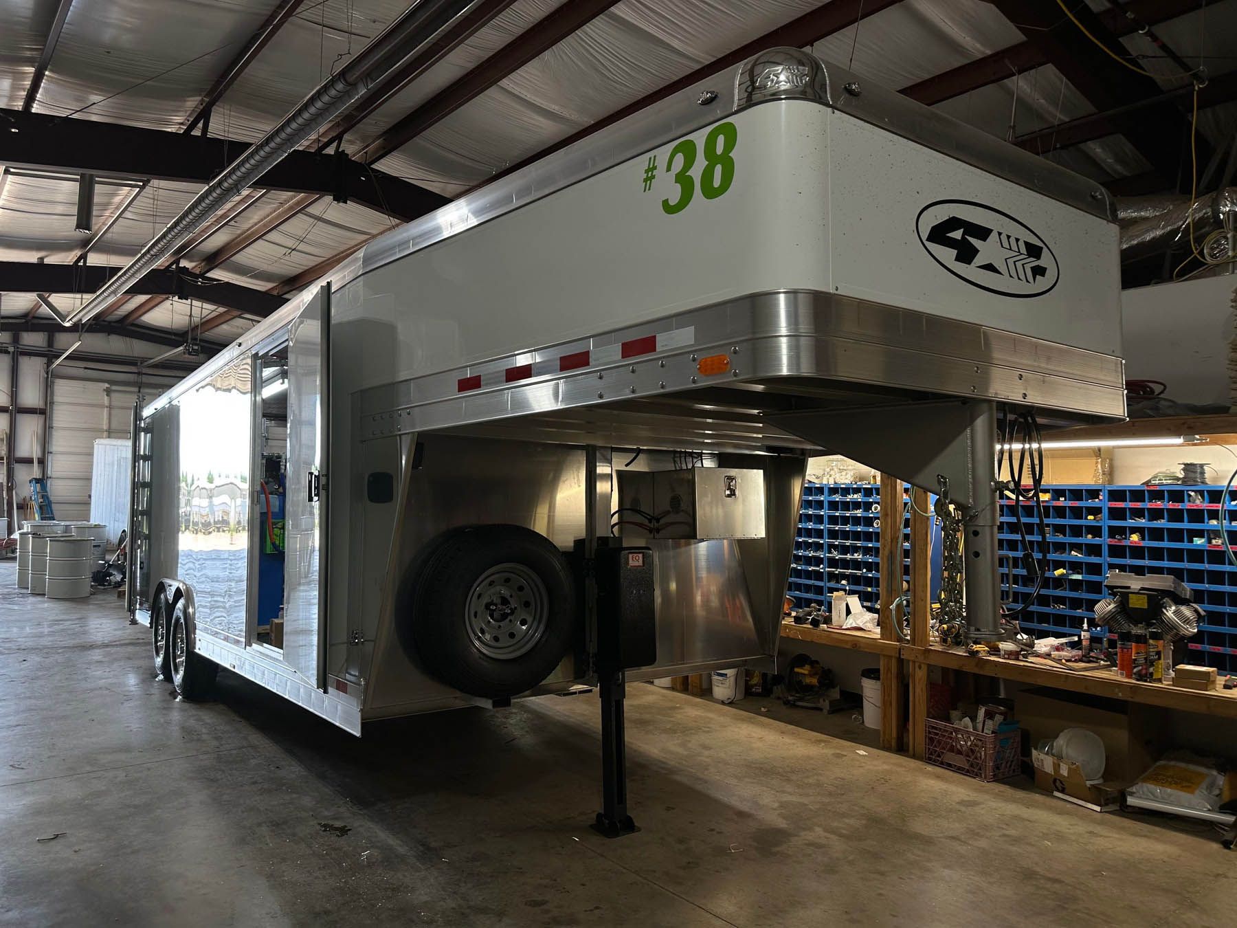White and silver horse trailer in a workshop.