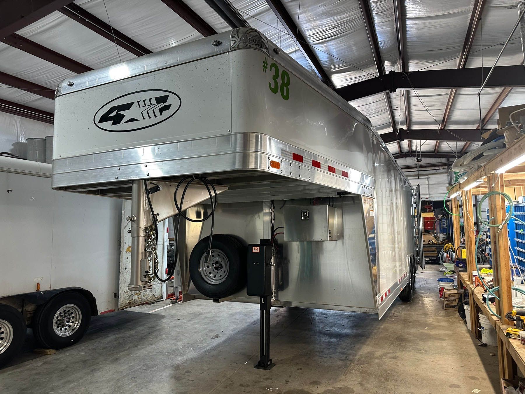 A horse trailer with the number 38 in a workshop setting.