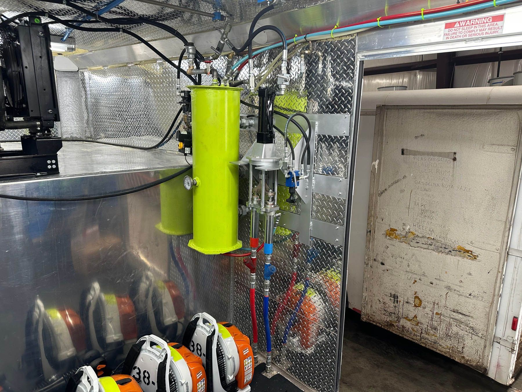 Inside a vehicle, cylinders and hoses with SCBA gear. A door is on the right.