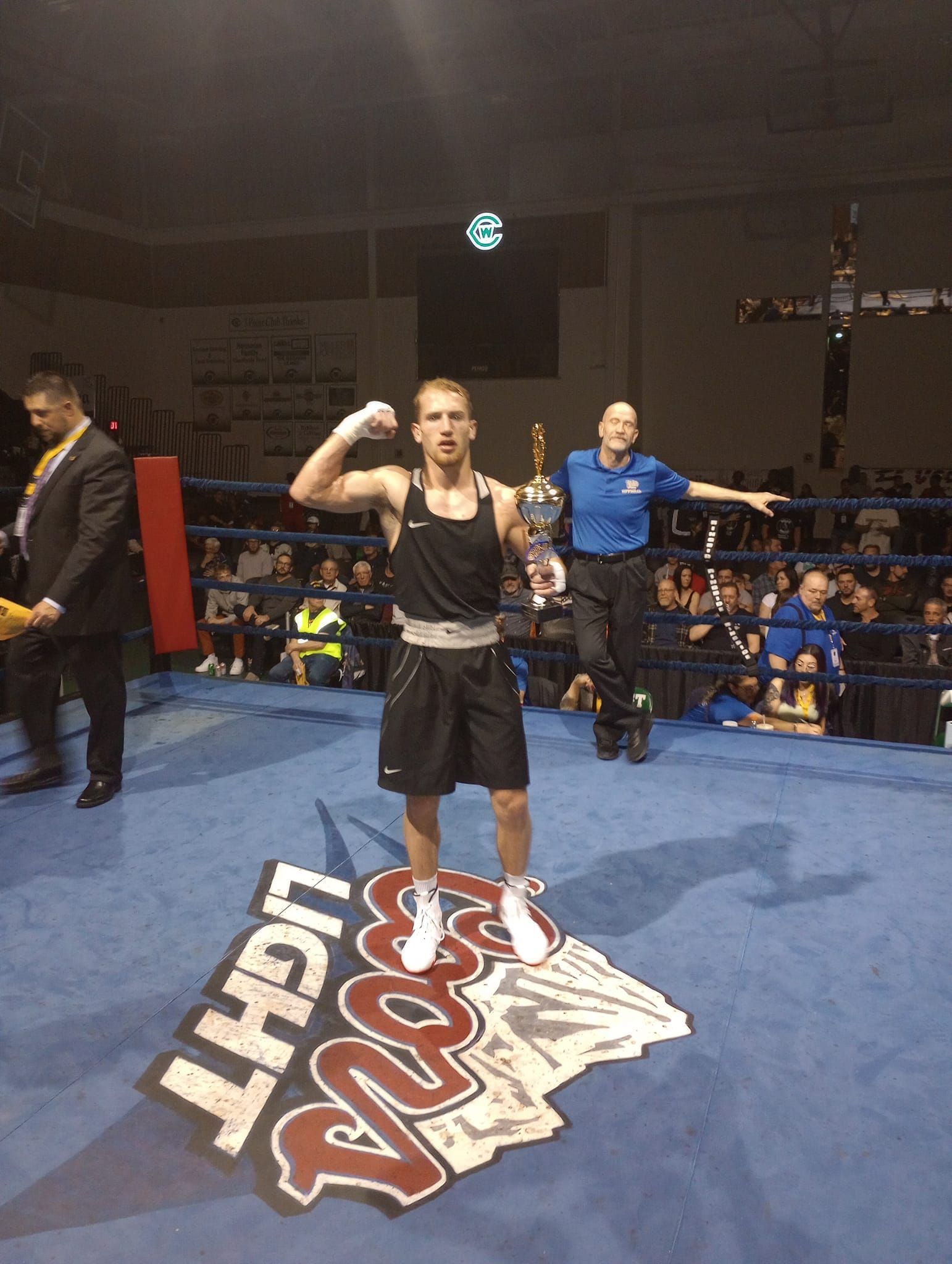 A man in a boxing ring with a light beer logo on the floor