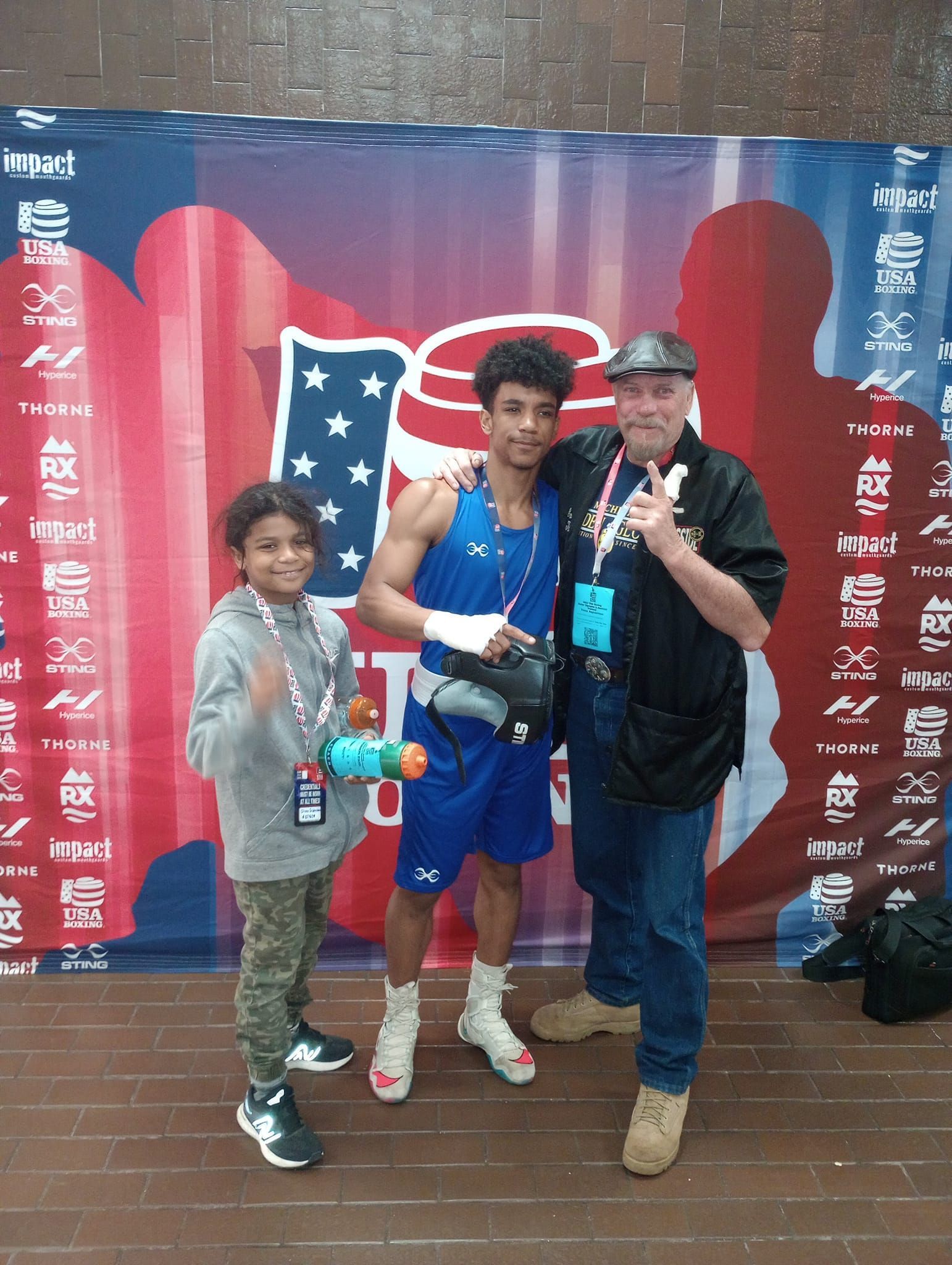 A man and two children pose for a picture in front of an american flag
