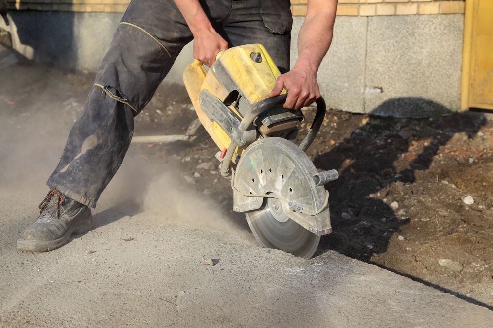 Person Cutting Concrete With a Yellow Power Saw — Coastcut Concrete Cutting Pty Ltd in Newcastle, NSW