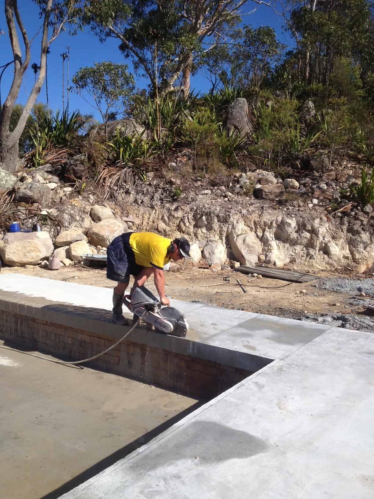 Person in Yellow Shirt Using a Concrete Saw on a New Concrete — Coastcut Concrete Cutting Pty Ltd in Newcastle, NSW