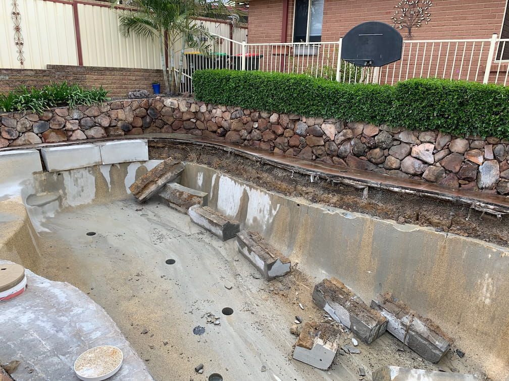 Empty Swimming Pool Under Renovation, With Scattered Debris — Coastcut Concrete Cutting Pty Ltd in Corlette, NSW
