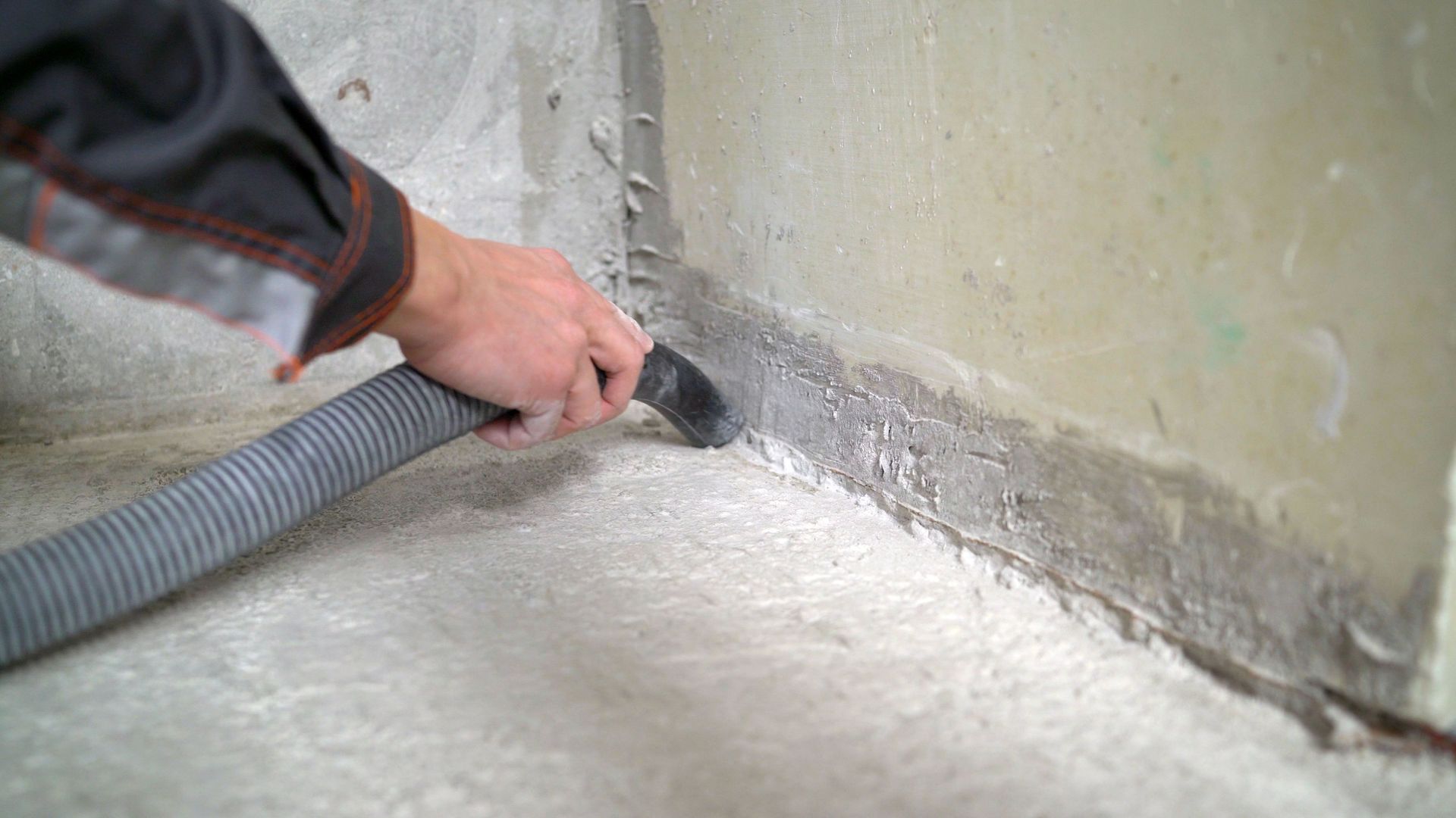 Person Vacuuming a Concrete Floor Near a Wall — Coastcut Concrete Cutting Pty Ltd in Port Stephens, NSW