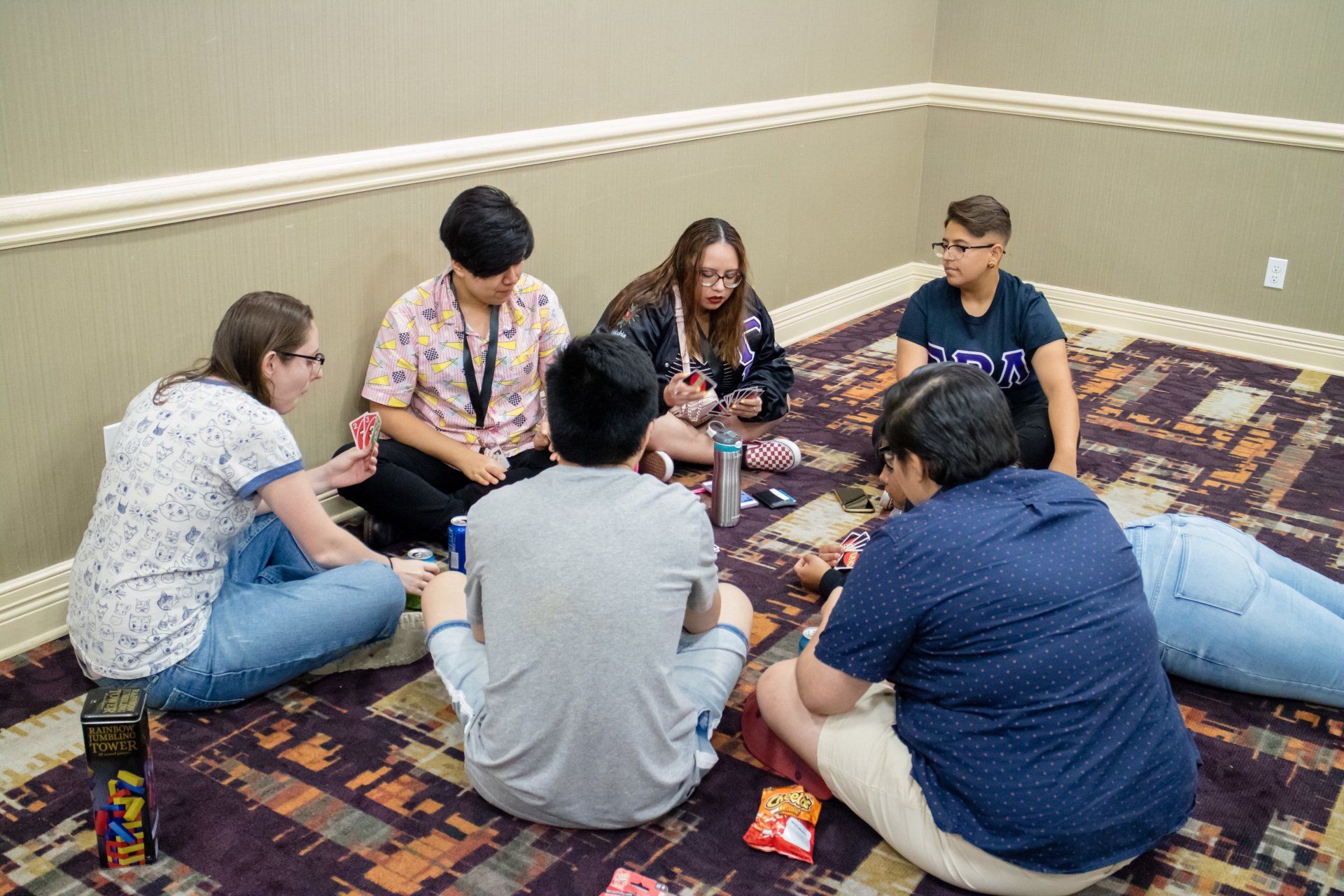 A large group of people siting on the floor, playing a game.