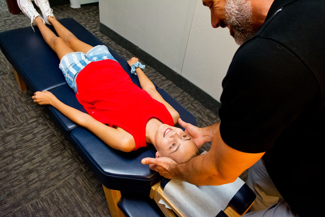 girl in red shirt getting a chiropractic adjustment