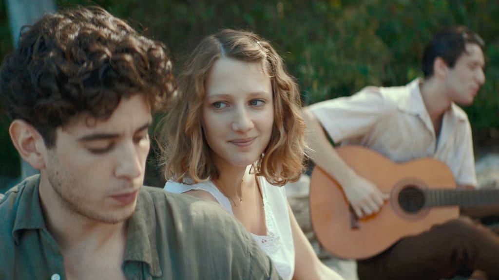 Eine Person mit Sonnenbrille und Kapuzenpullover blickt in die Kamera