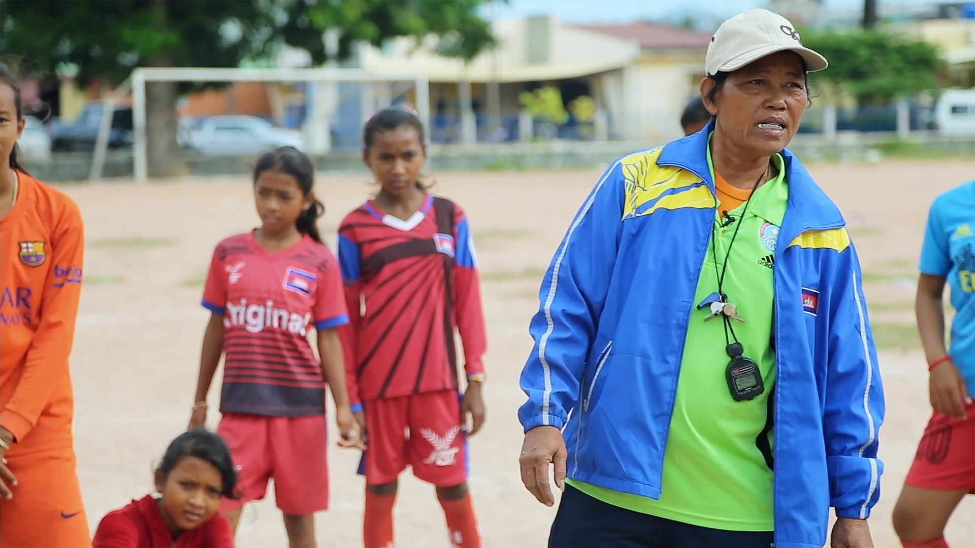 Eine Frau in einer blauen Jacke spricht mit einer Gruppe junger Kinder