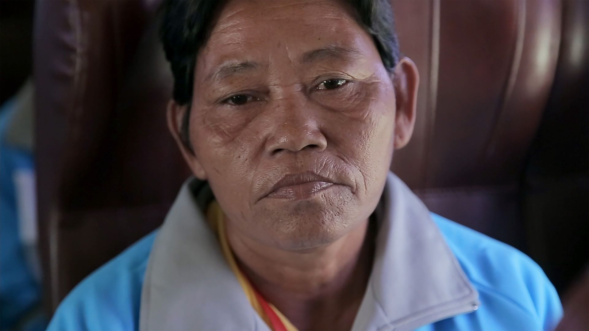 Eine Frau in einem blauen Hemd schaut in die Kamera