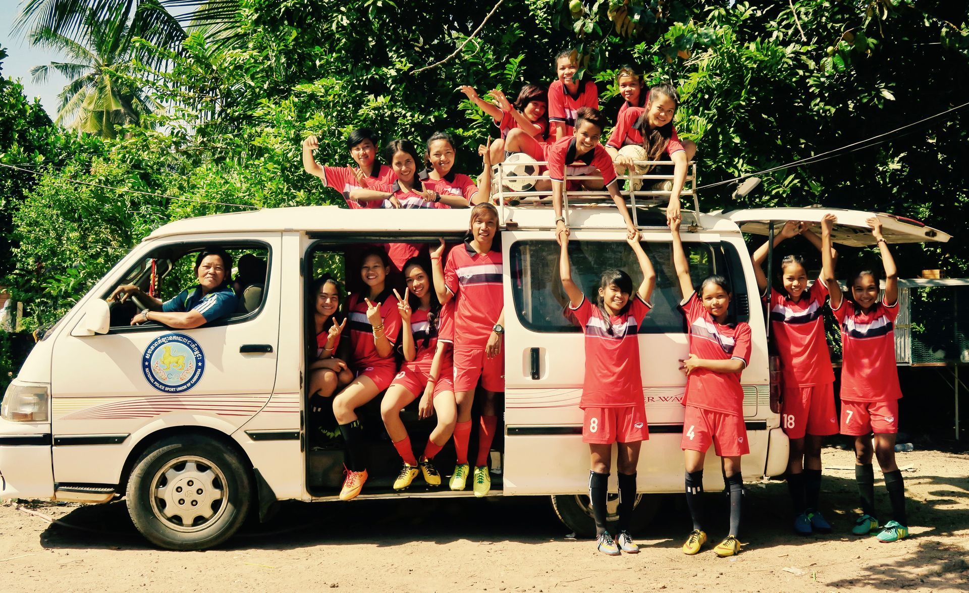 Eine Gruppe von Kindern posiert vor einem weißen Lieferwagen