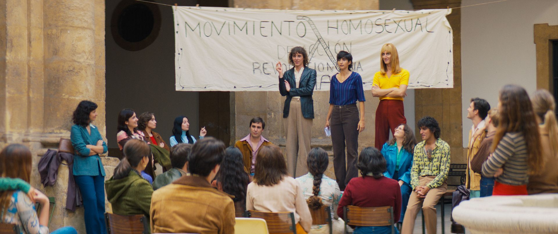 Zwei Frauen sitzen an einem Tisch mit Weingläsern und einer Schale Obst