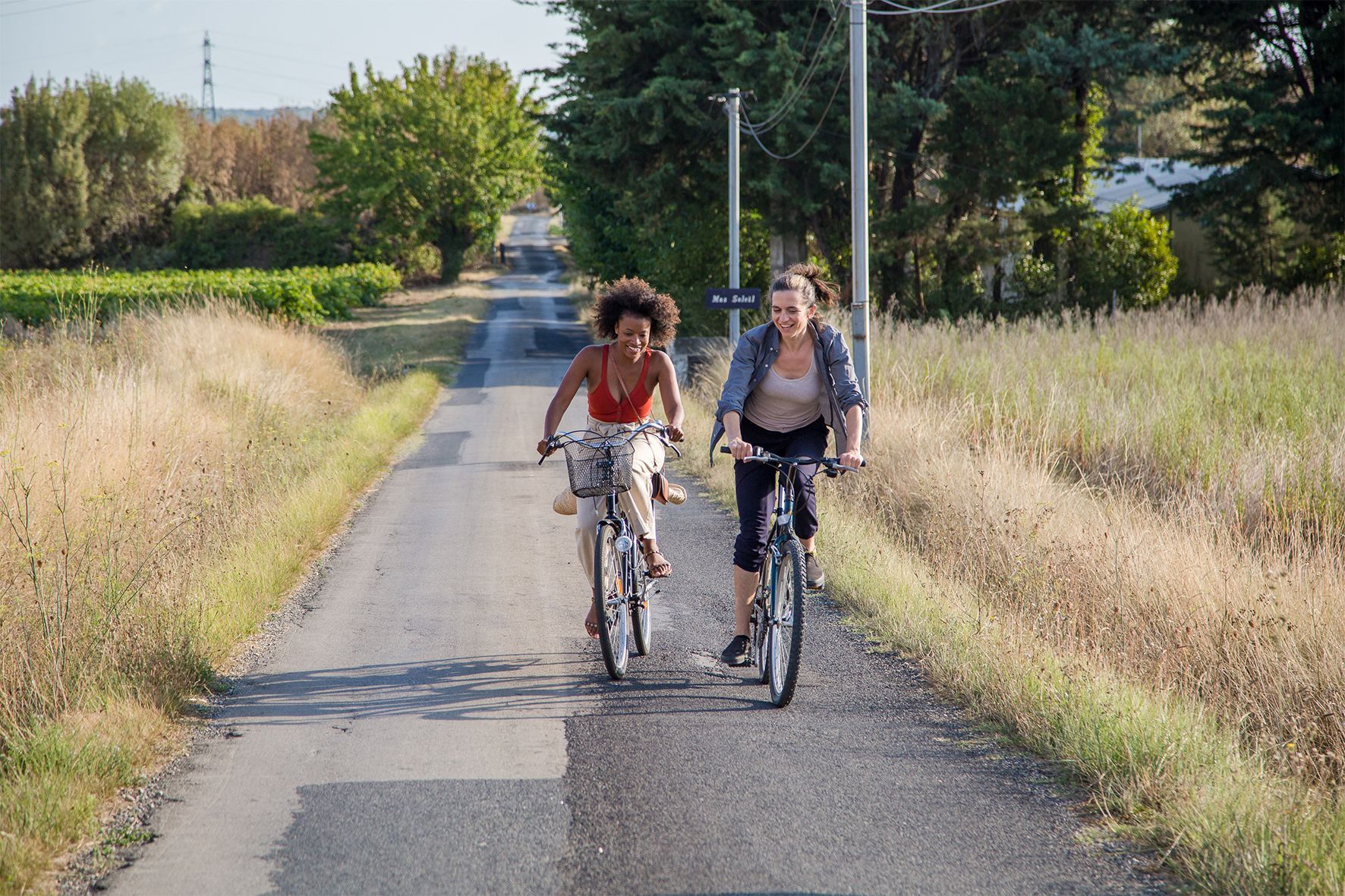 Zwei Frauen fahren mit dem Fahrrad eine Landstraße entlang