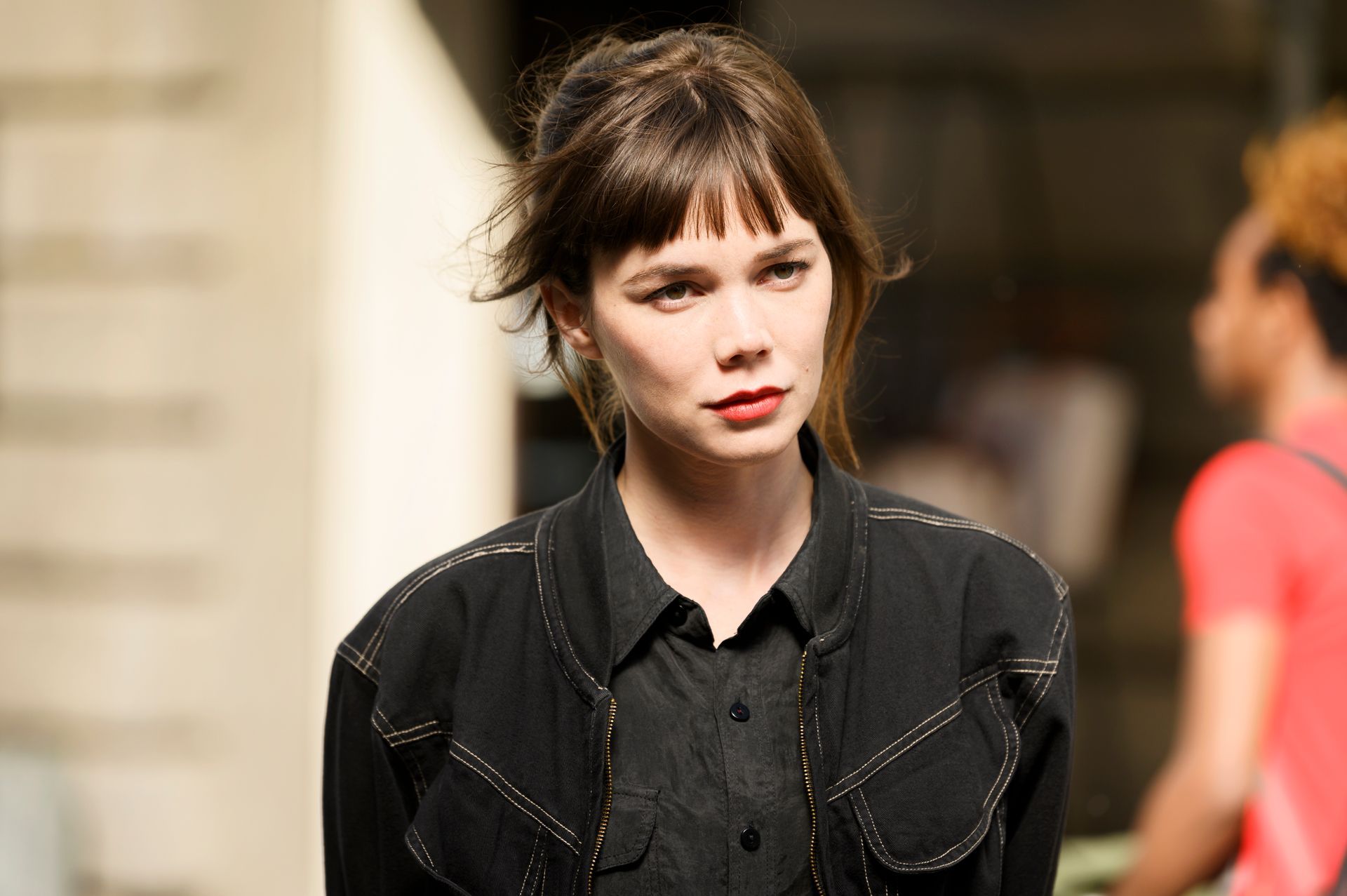 Eine Frau, die ein schwarzes Hemd und eine schwarze Jacke trägt