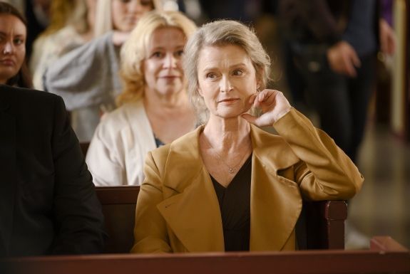 Eine Frau sitzt mit einer Gruppe von Menschen in einer Kirche.