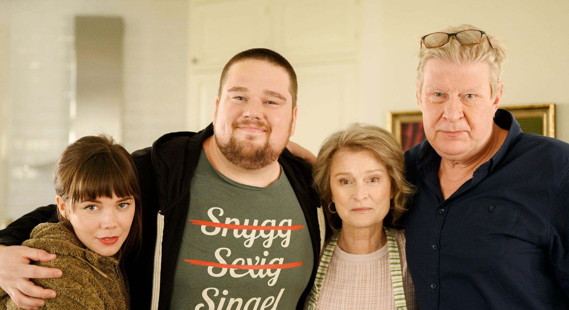 Eine Gruppe von Menschen, die für ein Foto posieren, wobei einer ein T-Shirt mit der Aufschrift „Singel“ trägt