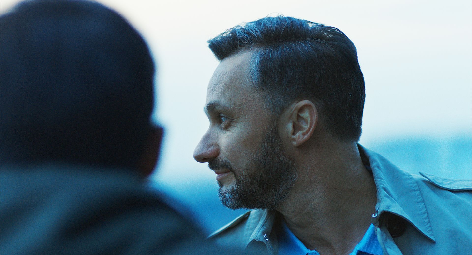 Ein Mann mit Bart spricht mit einem anderen Mann