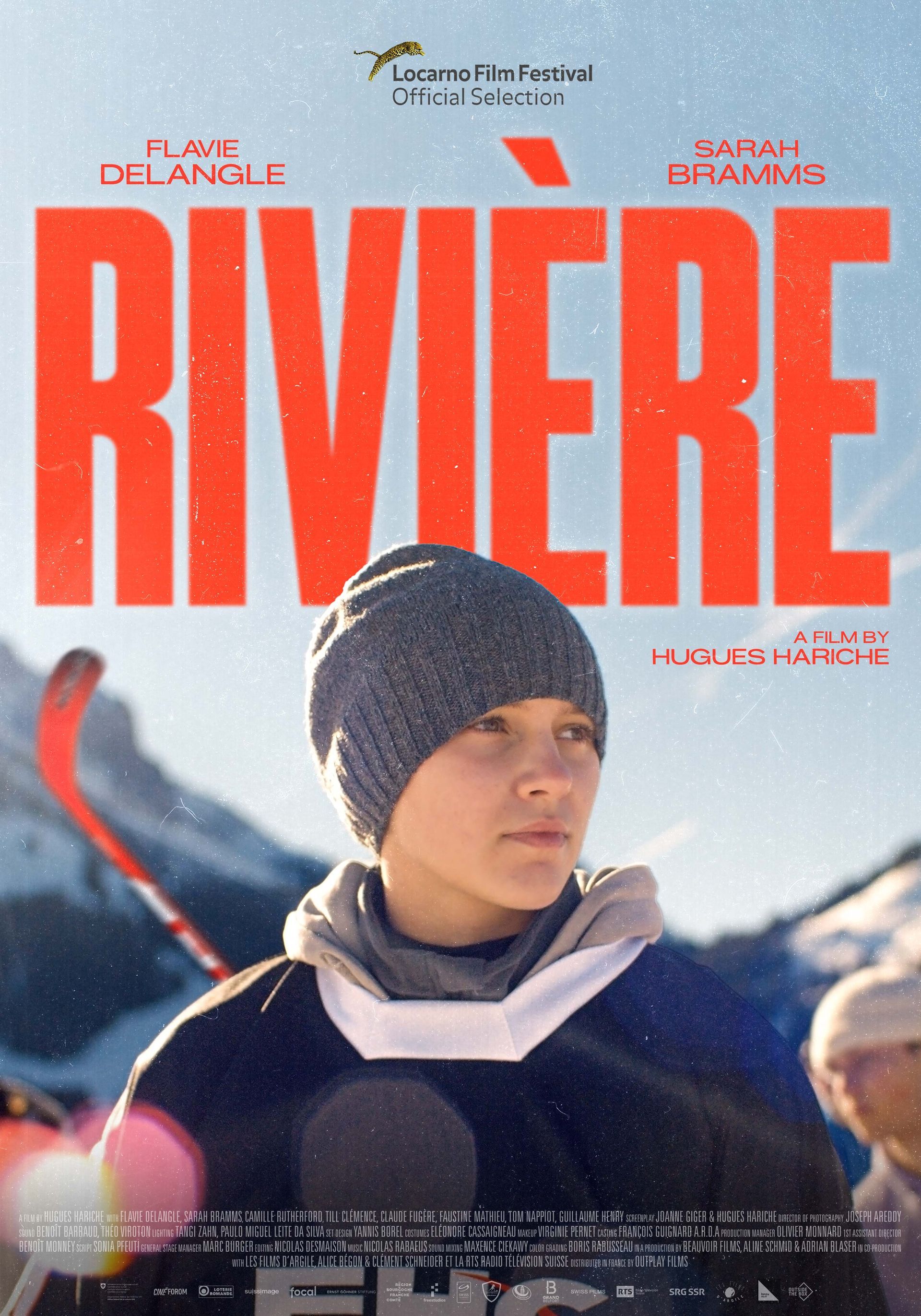 Ein Filmplakat für „Rivière“. Eine Person mit einer Strickmütze steht vor einem schneebedeckten Berg.