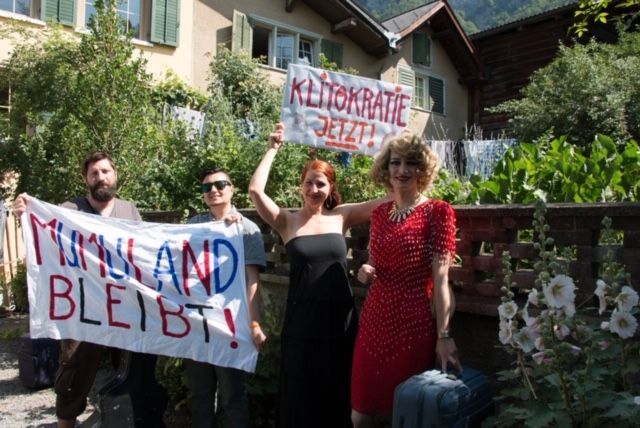 Eine Gruppe von Menschen hält ein Schild mit der Aufschrift „Mumuland bleibt“
